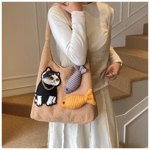 Détail du sac cabas en polaire camel avec broderie chat et breloques de poisson en peluche