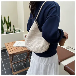 Nahaufnahme der cremefarbenen Hobo-Tasche mit detaillierter Kreuzwebstruktur am Modell