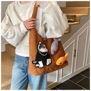 Détail du sac cabas marron en peluche avec broderie de chat et breloques de poisson