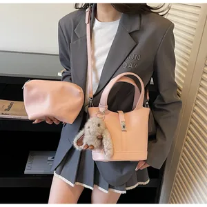 Pink bucket bag and crescent pouch in lychee grain leather with plush bunny charm