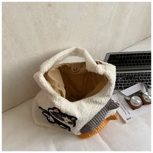 Détail du sac cabas en peluche blanche avec broderie de chat et breloques de poisson