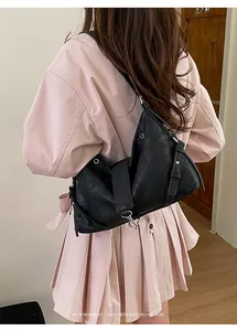 Détails d'un sac hobo en cuir noir avec ferrures argentées et style rétro minimaliste