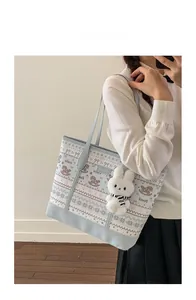 Detail of light blue tote bag with pattern prints and cute plush rabbit charm