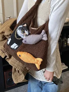 Cabas en polaire peluche marron avec écusson chat et breloques poisson sur modèle