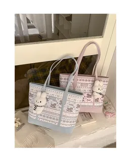 Detail of canvas tote bags in pastel blue and pink with cute prints and rabbit charms