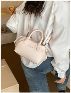 Detail of light pink pebble leather tote bag with elegant tassel and fashion text branding