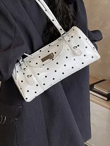 Sac baguette à pois avec clous argentés et double sangle sur mannequin au style chic
