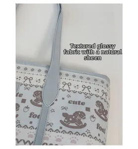Detail of light blue tote bag showing cute foal patterns and textured glossy fabric