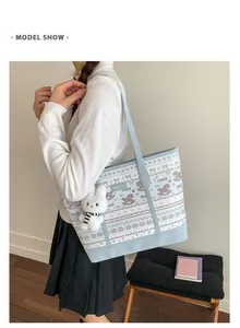 Side view of a large blue floral tote bag with a plush bunny charm on a female model