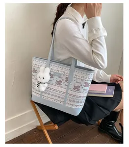 Detail of light blue tote bag with cute foal print and plush bunny keychain accessory