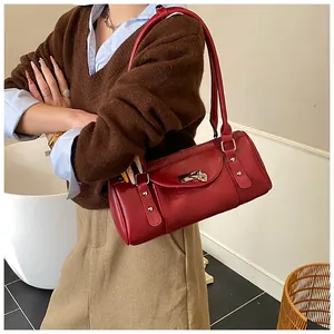 Sac Boston cylindrique rouge avec fermoir coeur argenté porté à l'épaule