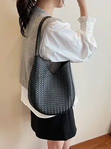 Klassische schwarze geflochtene Intrecciato Leder-Beuteltasche an einem Model
