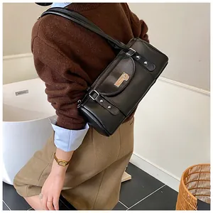 Gros plan d'un sac polochon noir brillant avec des détails en métal argenté