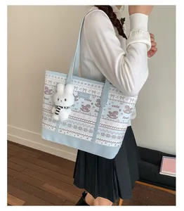 Detail of light blue canvas tote bag with horse prints and a cute plush bunny charm