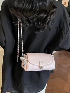 Sac baguette en cuir rose clair avec bandoulière chaîne et bijou de sac chien