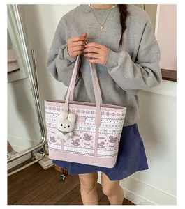 Detail of pink and white tote bag featuring cute foal prints and a plush bunny charm