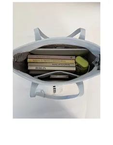 Top view of blue tote bag showing spacious striped interior with laptop and daily items