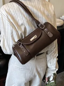 Sac bandoulière cylindre marron foncé minimaliste avec lanières en cuir et boucle métal