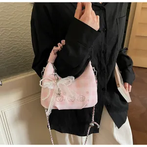 Detail of pink plaid pleated handbag with bear embroidery and lace bow decoration