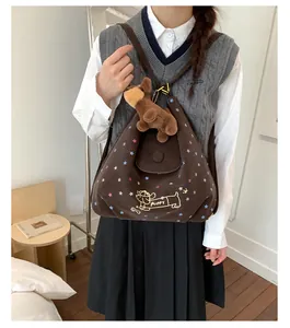 Detail of dark brown star print backpack featuring cartoon puppy design and plush charm