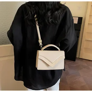 Minimalist beige textured leather handbag styled with an oversized black shirt for a chic look