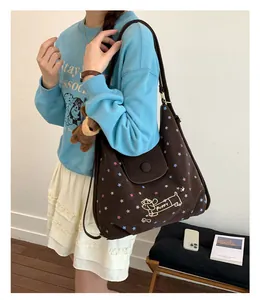 Detail view of canvas tote bag with puppy print, star pattern and plush bear charm