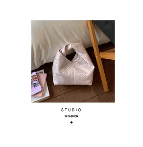 Détail du sac à main jacquard rose clair avec motif floral géométrique et élégant