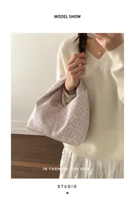 Vue mannequin du sac bourse en tissu rose et blanc avec motifs floraux géométriques