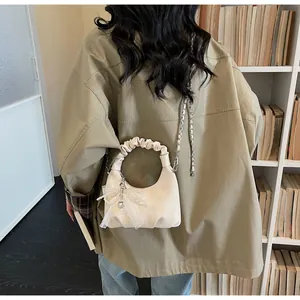Close-up of cream pleated bag with lace bow and cute bear prints on soft leather