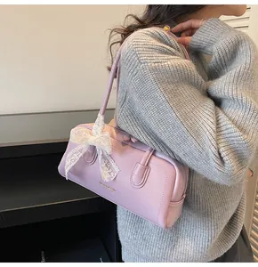 Détail du sac Boston lilas avec nœud en dentelle blanche et bandoulière réglable