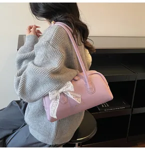 Détail du sac Boston lavande avec noeud en dentelle et logo Maven & Chic