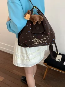 Brown star pattern backpack with puppy graphic and plush toy shown on model