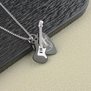Dettaglio macro di ciondoli a forma di chitarra elettrica e plettro in acciaio inox