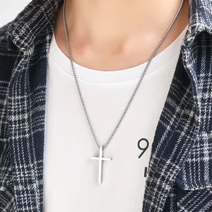 Minimalist titanium steel cross pendant necklace in silver worn over a casual outfit