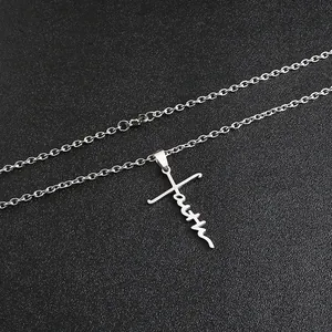 Dettaglio del ciondolo a croce in acciaio inossidabile argento con scritta faith