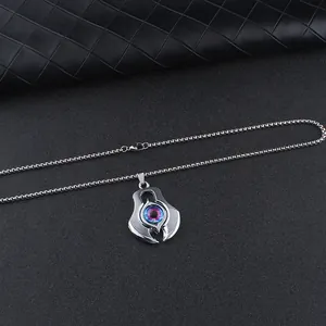 Macro shot of silver demon eye pendant with vibrant gradient iris and bead chain