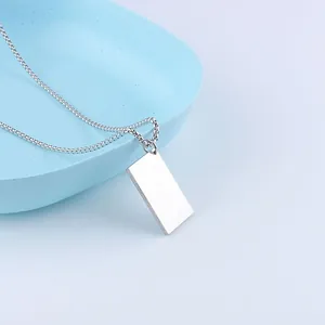 Macro view of polished silver stainless steel rectangle tag pendant and box chain