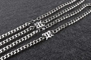 Dettaglio catena cubana in acciaio argento con chiusure a moschettone e a forma di 8