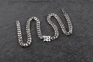 Dettaglio della catena cubana d'argento con un ciondolo a forma di lettera B gotica
