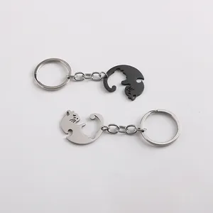 Macro detail of interlocking black and silver cat couple keychains in polished metal