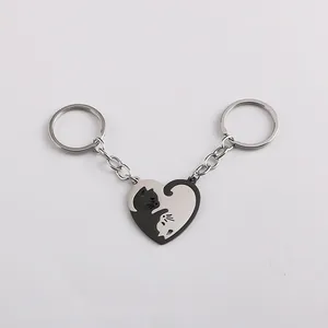 Detail of two-piece heart cat keychains for couples in black and silver stainless steel