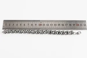Detail view of gothic skull link bracelet in vintage silver finish with measurement scale