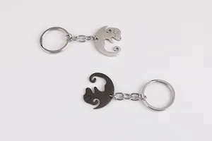 Macro shot of silver and black stainless steel cat-shaped interlocking couple keychains