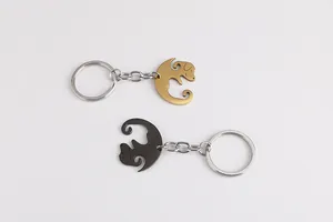 Detail view of interlocking gold and black dog pendants on stainless steel keychains
