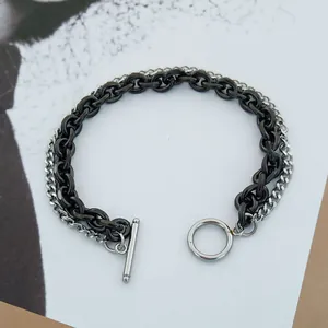 Close-up of double-layer black and silver stainless steel chain bracelet with OT toggle clasp