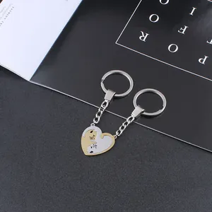Detail of heart-shaped cat couple keychain in gold and silver metal puzzle design