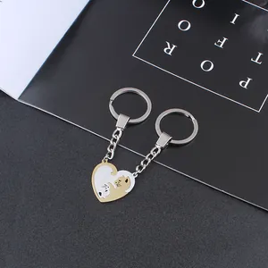 Close-up of interlocking heart-shaped cat keychains in gold and silver metal finishes