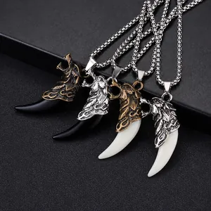 Close-up of ethnic wolf fang pendants with detailed metal carving in multiple color options