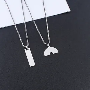 Detailed view of silver rainbow geometric pendants and sturdy box chains on a textured base