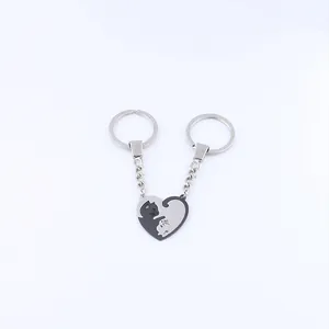 Close-up of heart-shaped stainless steel cat couple keychains with silver and black finish